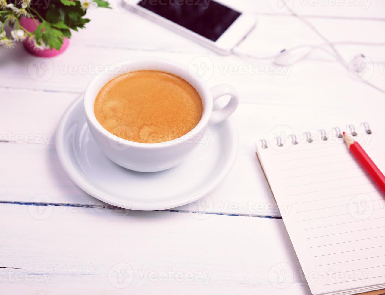 cup of coffee and an empty paper notebook photo