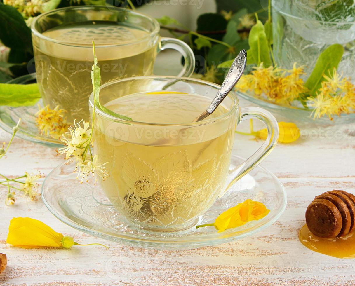 taza transparente con té de tilo en una tabla de madera blanca foto