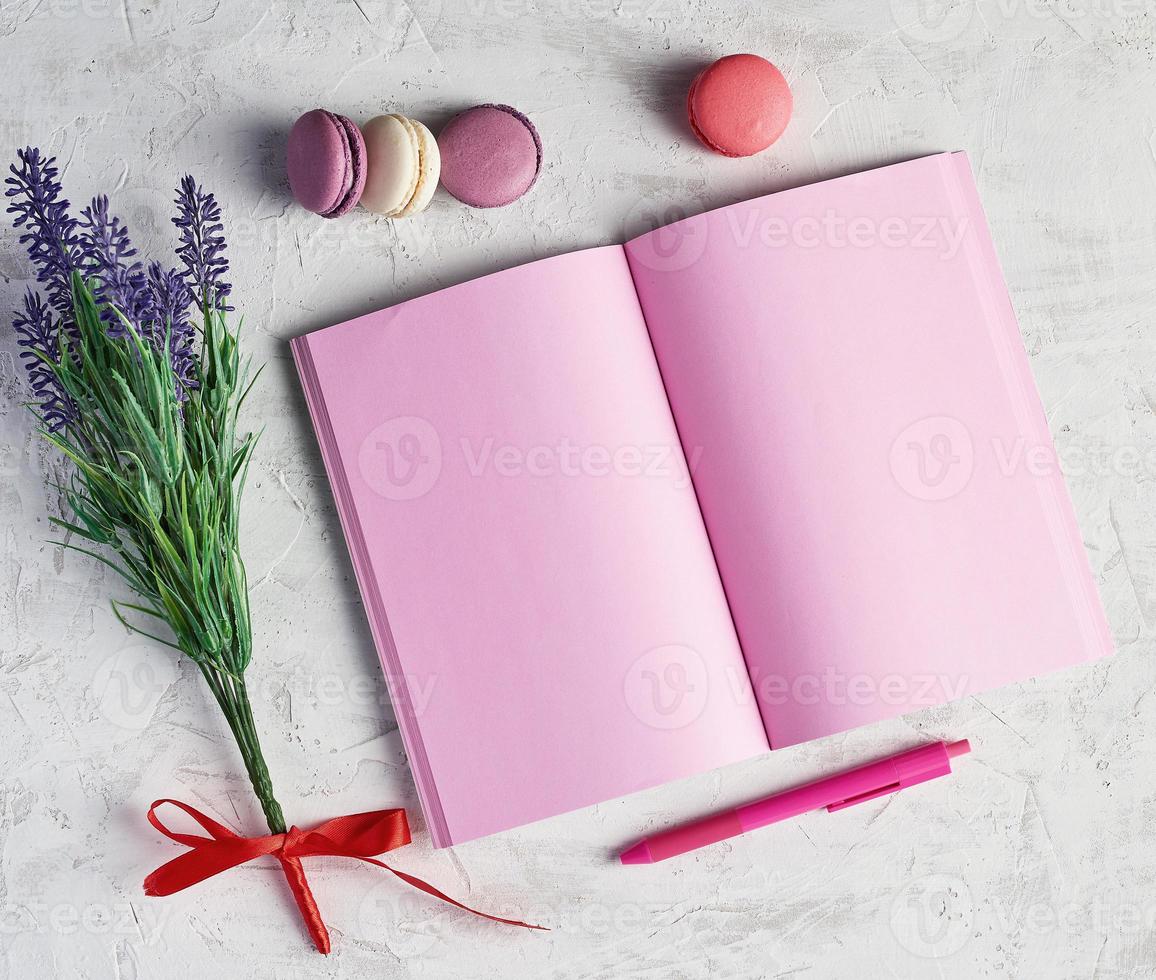 open notebook with blank pink pages, red pen photo