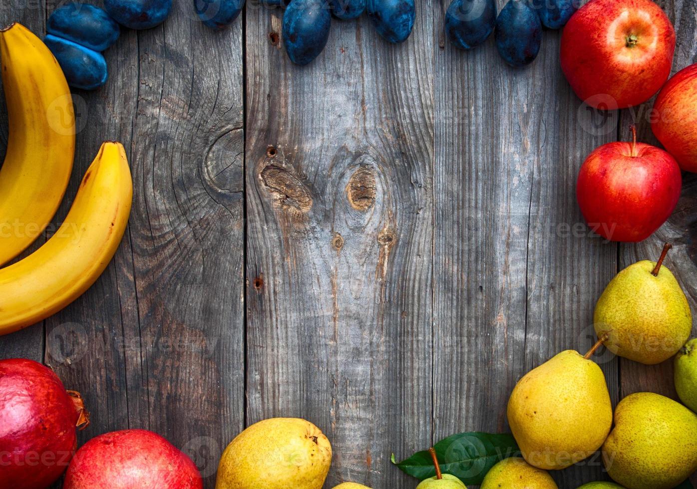 Ripe fruits lined frame on a gray wooden surface photo