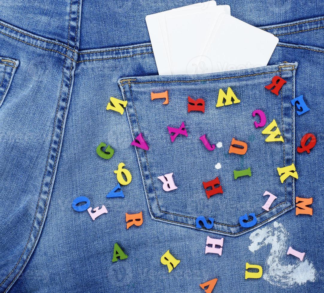 colored wooden letters scattered on blue jeans photo