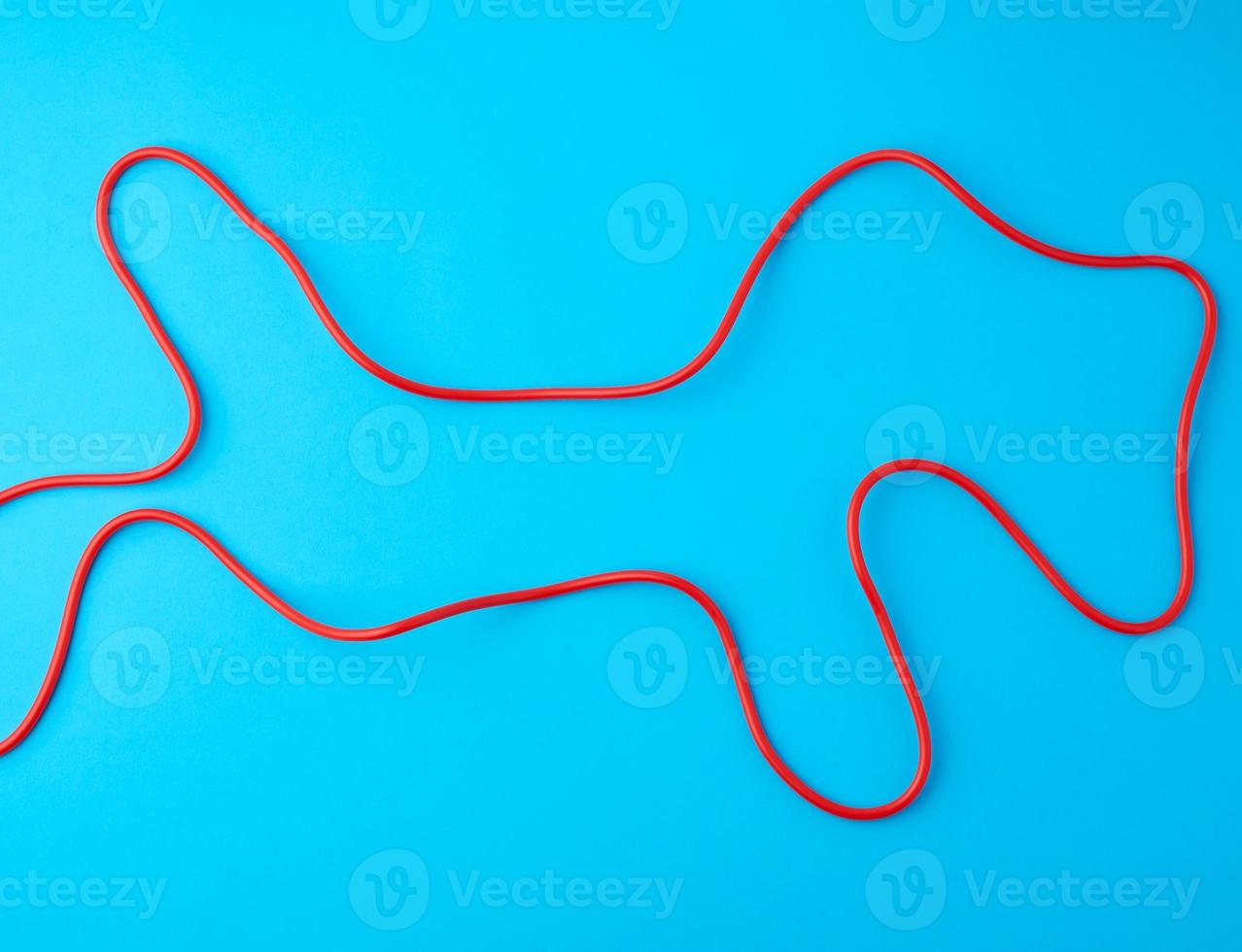 fragment of a red jump rope for sports on a blue background photo