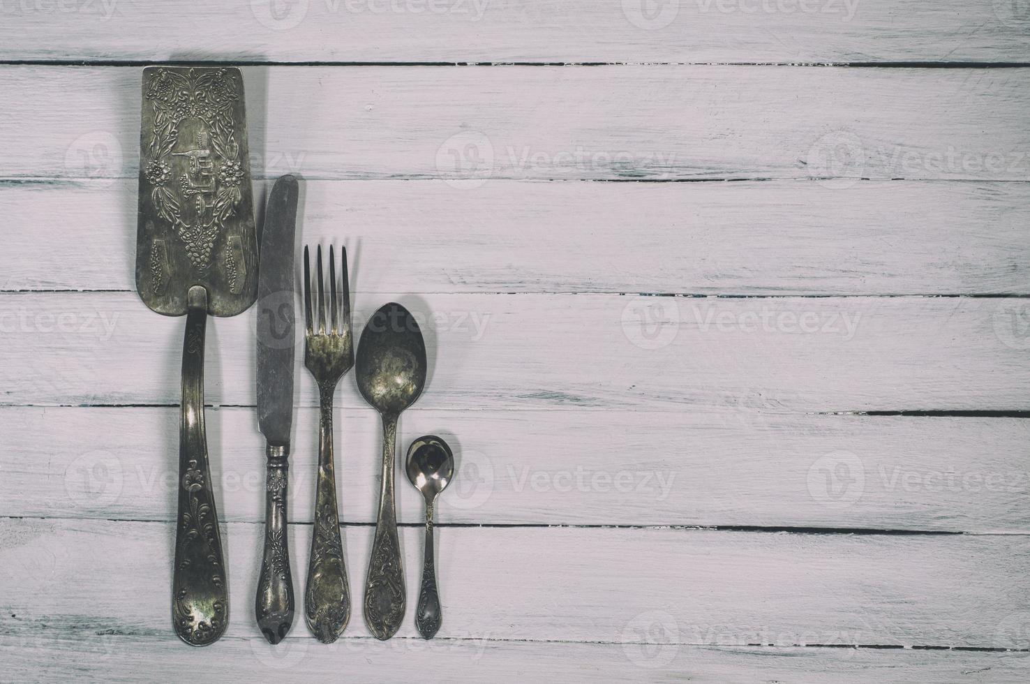 Vintage cutlery on a white wooden background photo