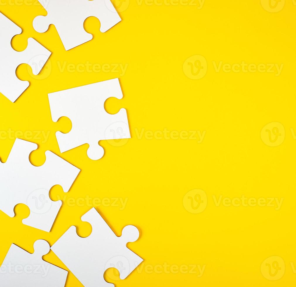 blank white big puzzles on yellow background photo