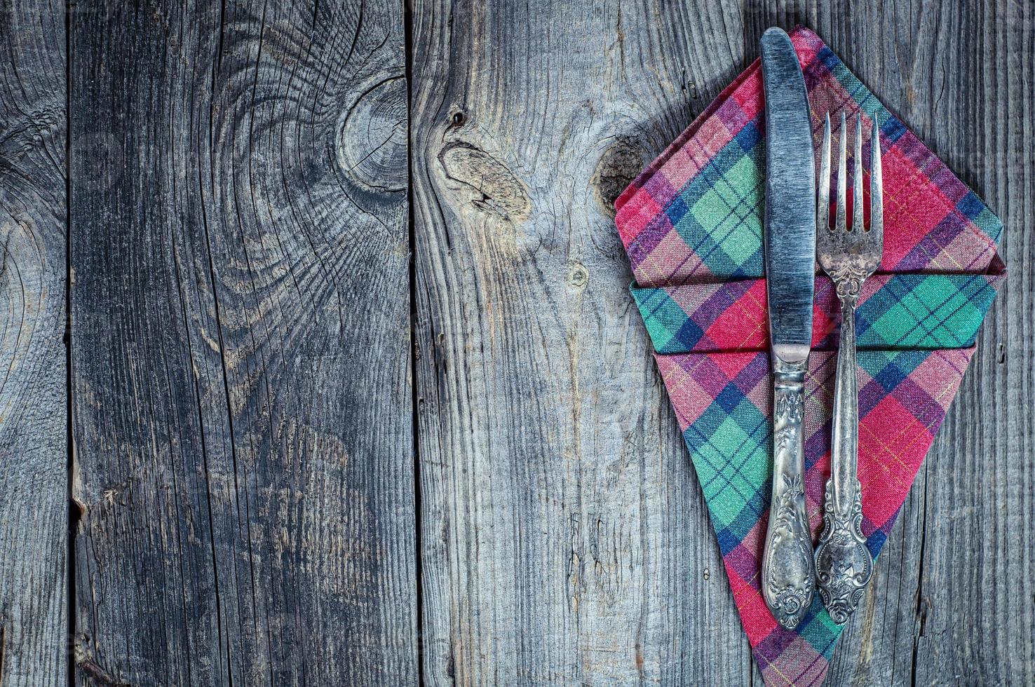 Fork and knife on a napkin, gray old wooden table photo