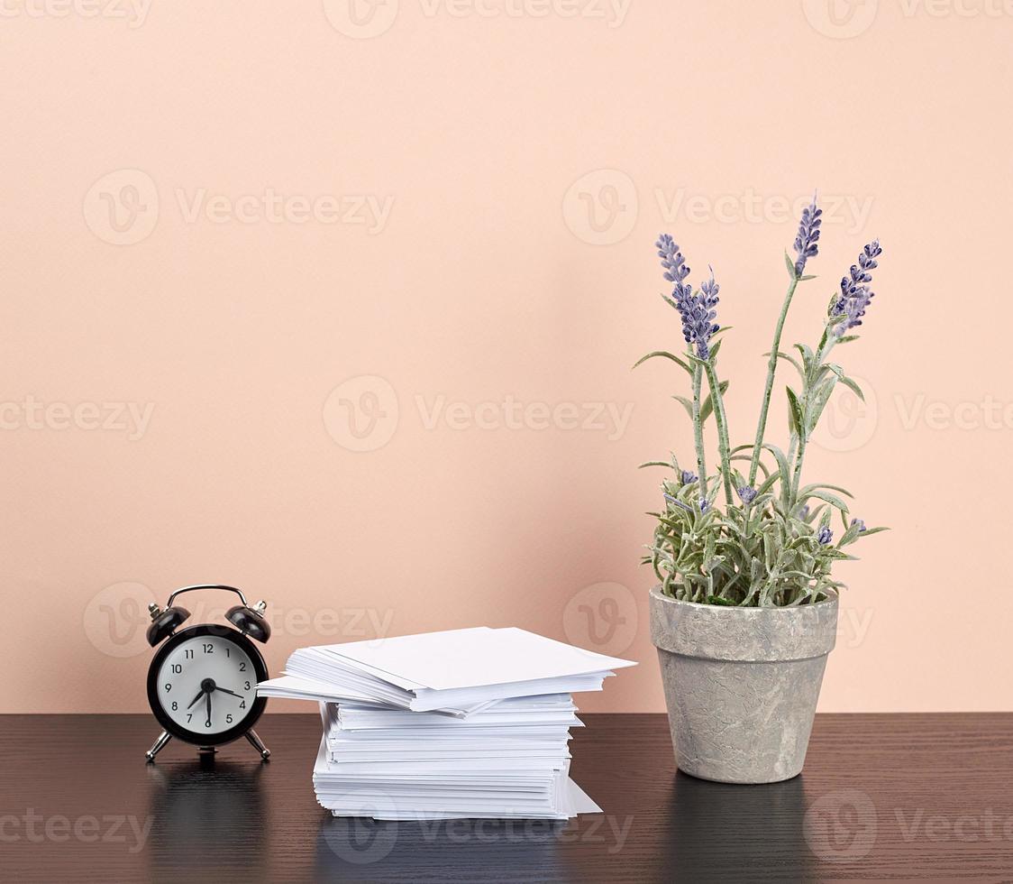 stack of white square note papers, a ceramic pot of lavender and an alarm clock photo