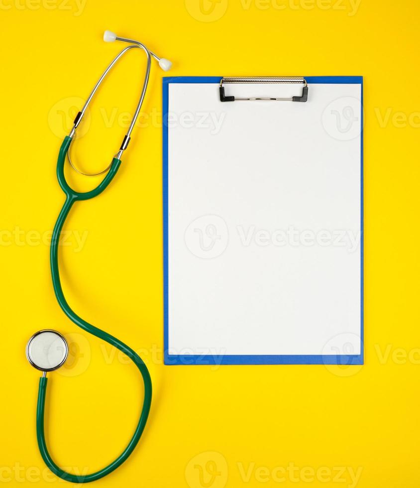 empty white sheets and medical stethoscope on a yellow background photo