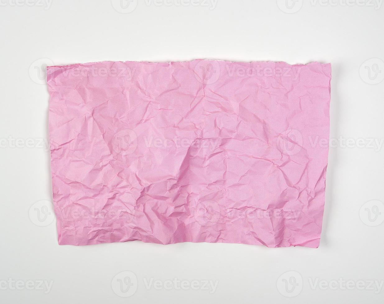 crumpled pink rectangular sheet of paper on a white background photo