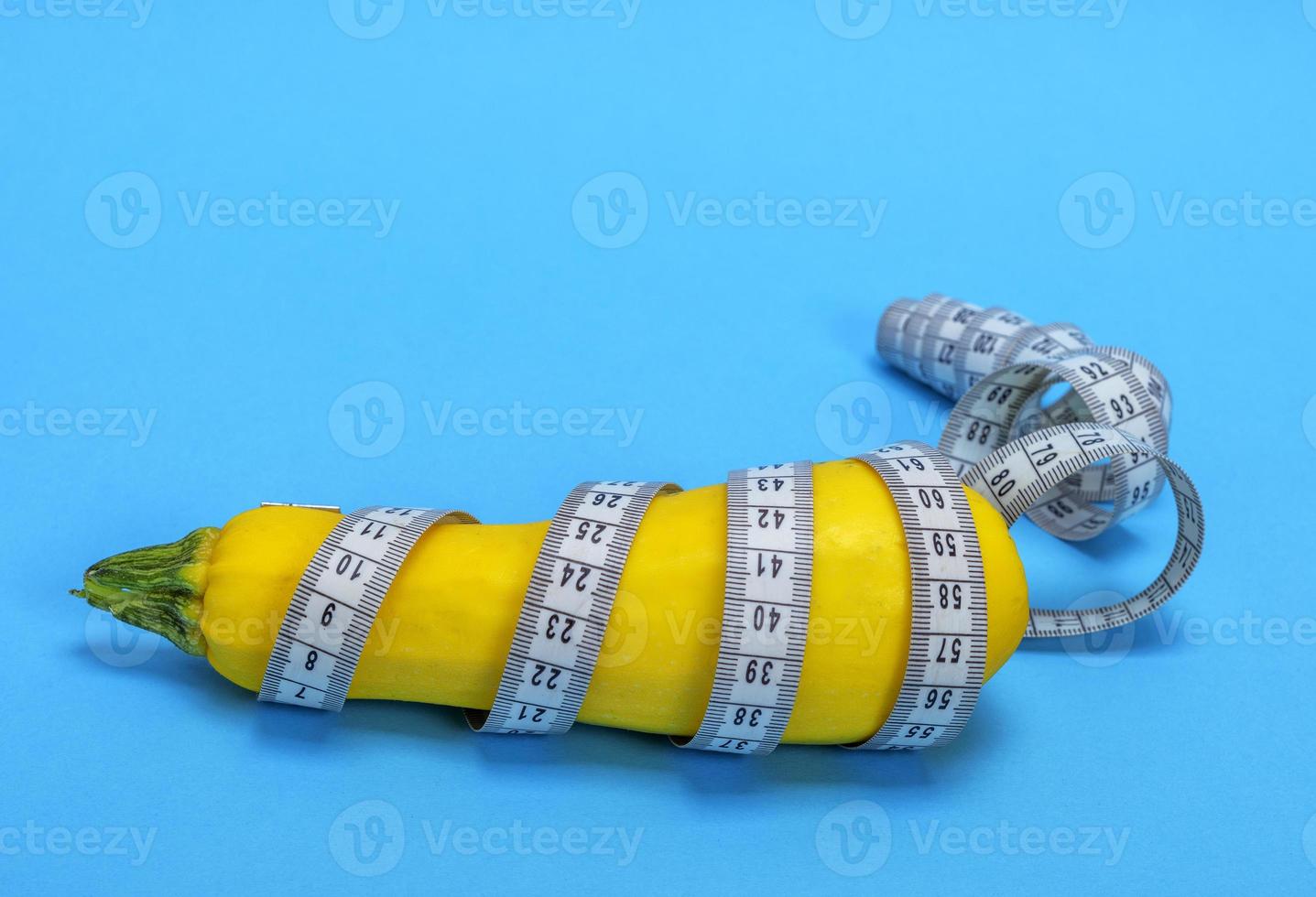 yellow raw zucchini wrapped in a measuring tape photo