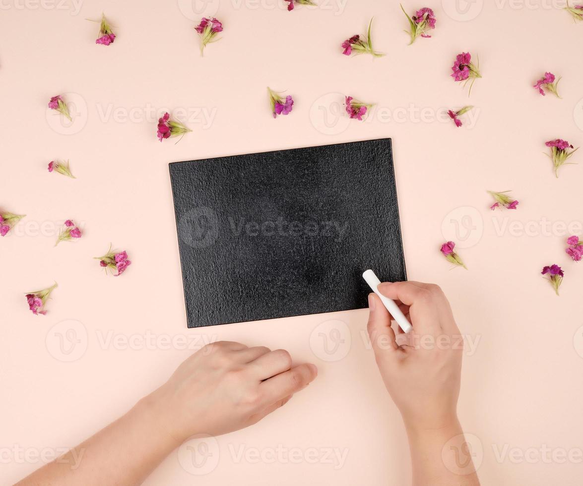 black chalk frame and two female hands with a piece of white chalk photo