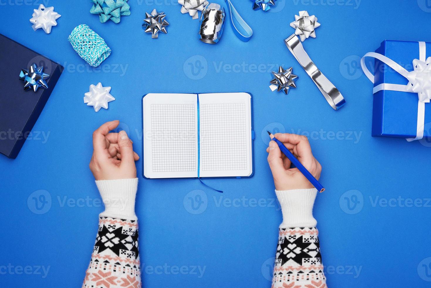 open notebook with empty white sheets and two female hands photo