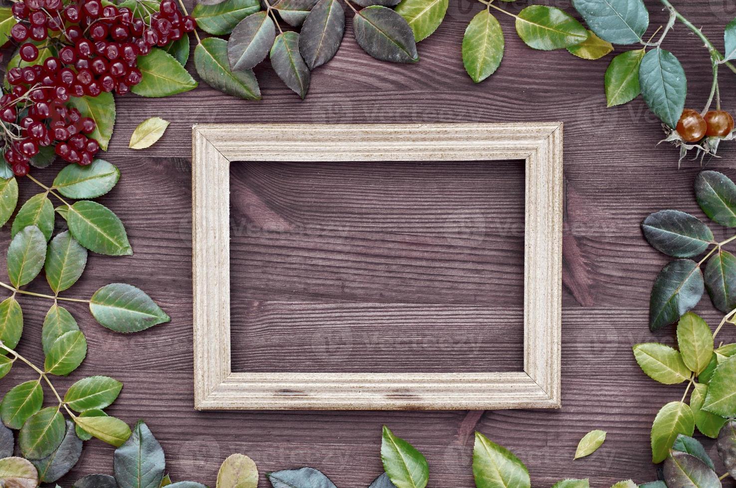 empty wooden frame on a brown surface among the leaves photo