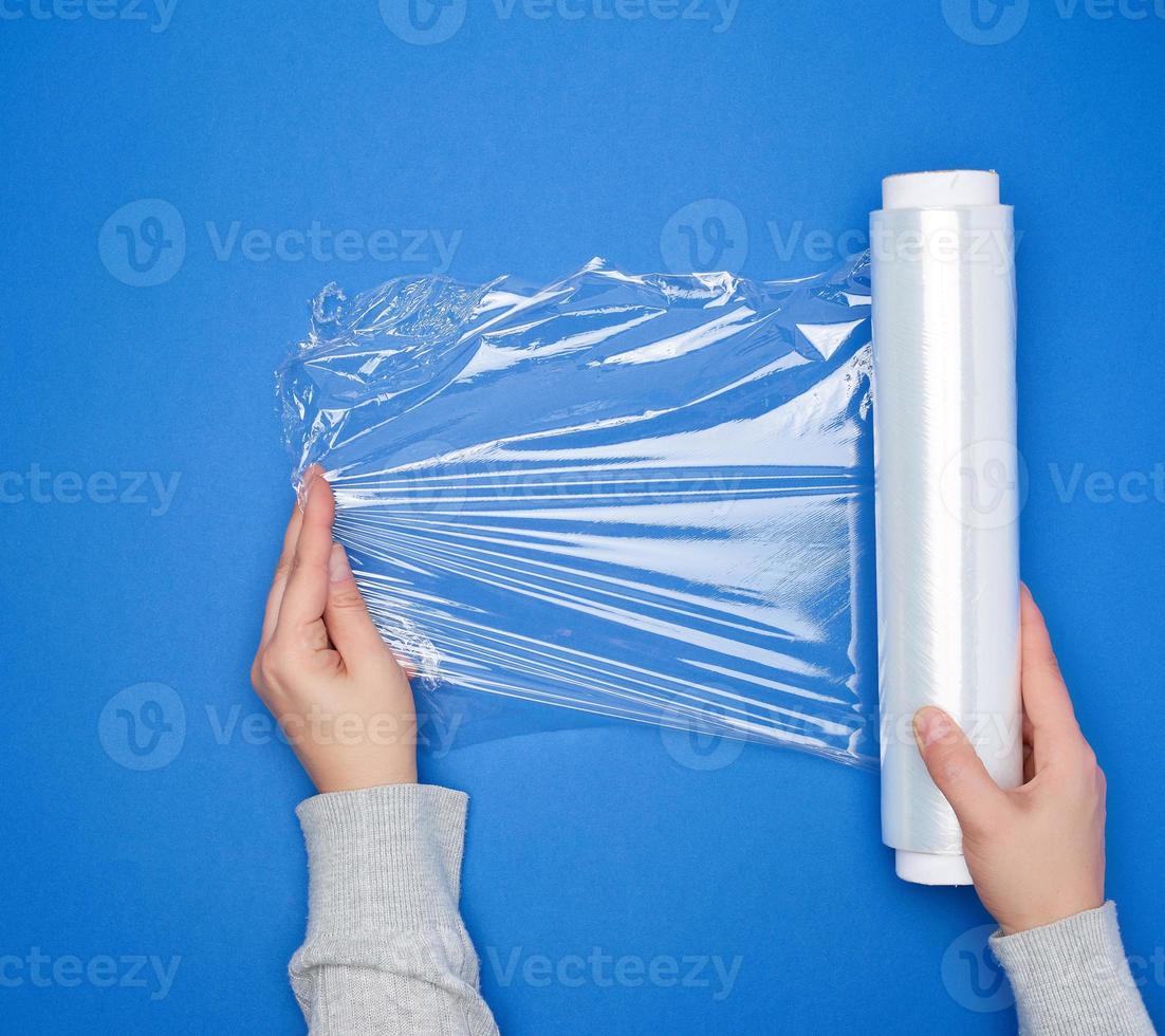 hand hold a large roll of wound white transparent film for wrapping food photo