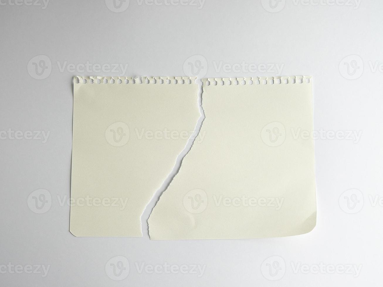 sheet of white paper torn in half with a spiral notepad photo