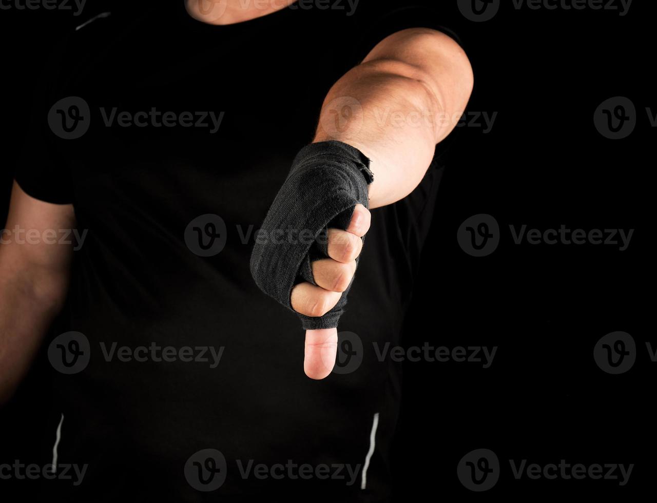 adult athlete in black uniform and hands rewound with textile bandage photo