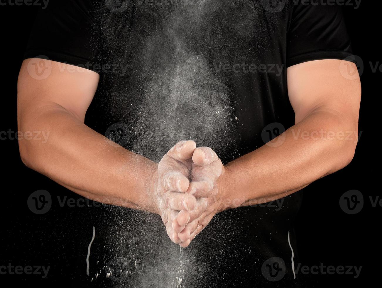 athlete in black clothes clapping, white talc magnesium fly away photo