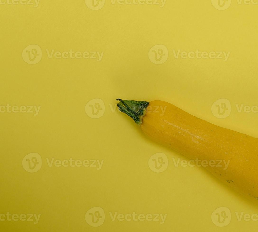 ripe yellow zucchini on a yellow background photo