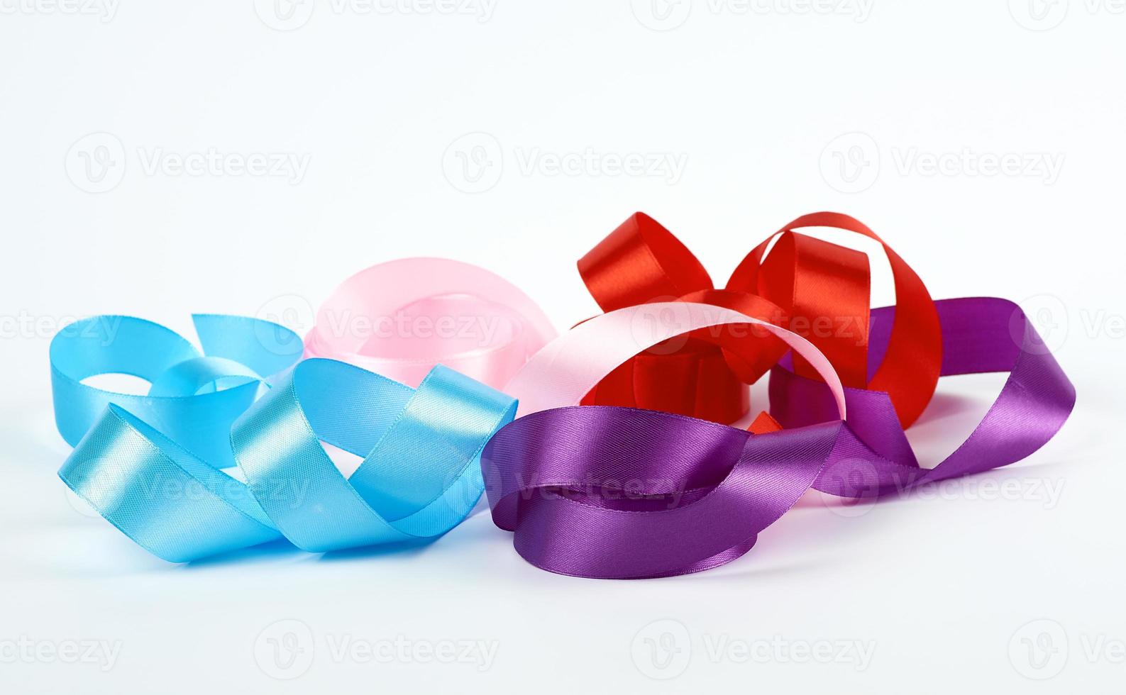 blue, pink, red and purple satin twisted ribbons on white background photo