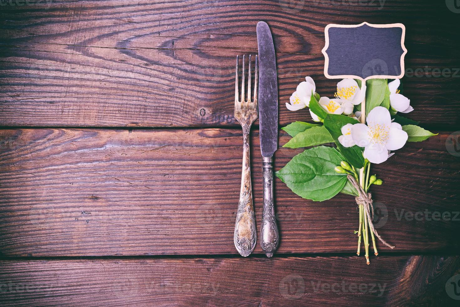 Iron vintage cutlery with a bouquet of jasmine photo