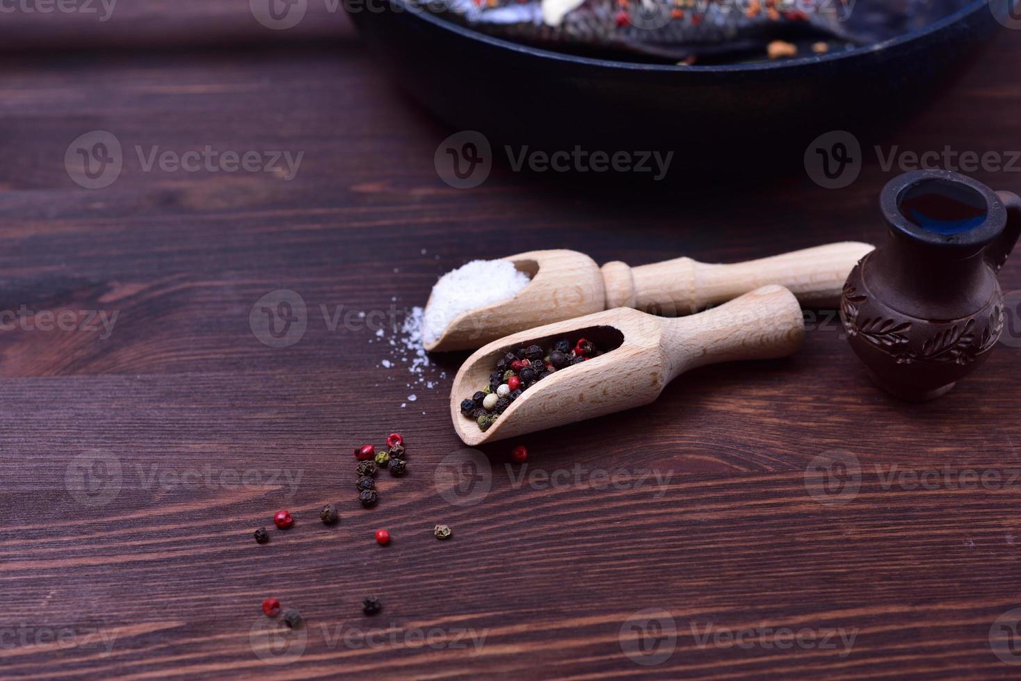 Mixture of black and red pepper in a wooden spoon photo