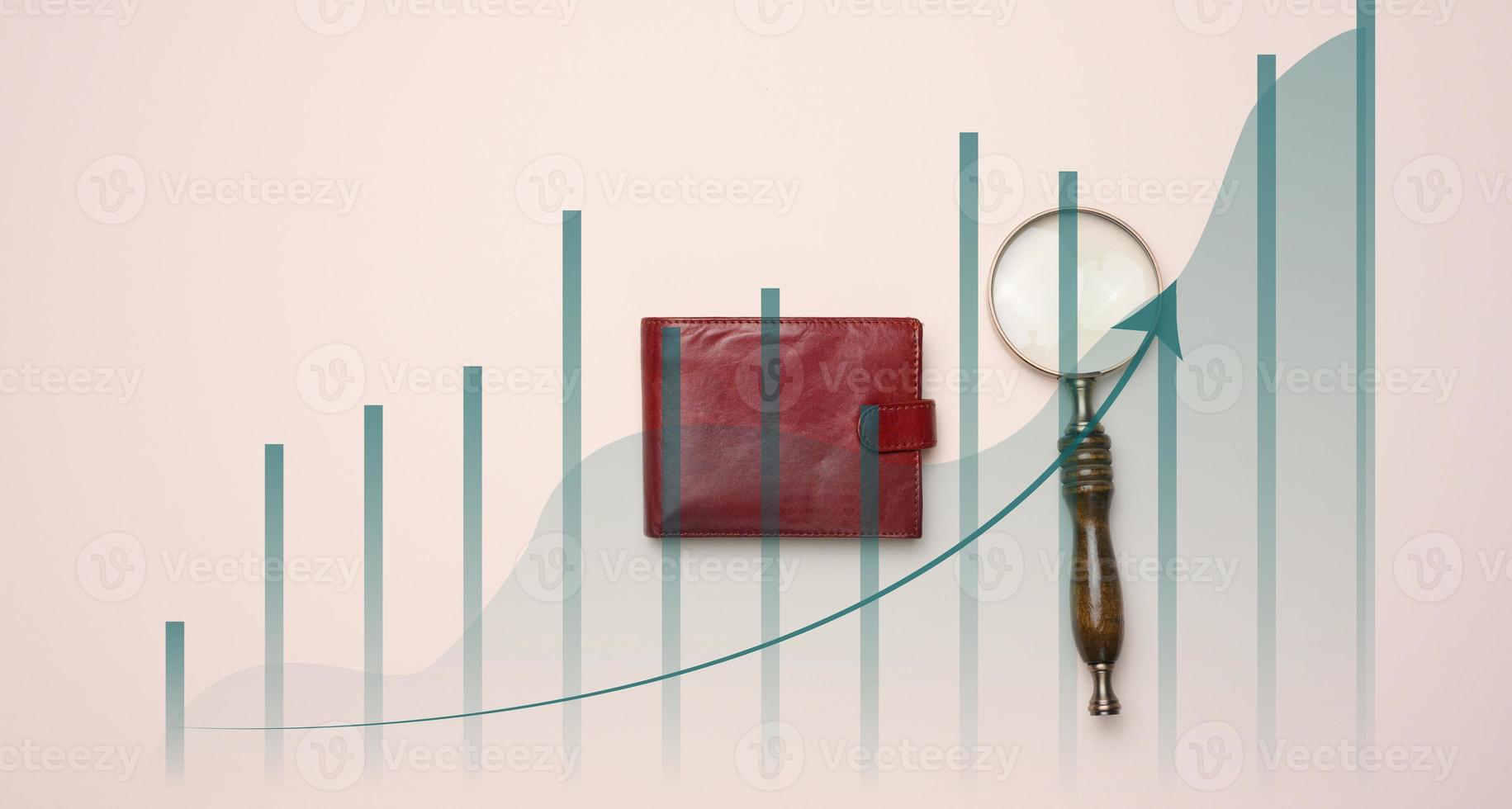 magnifying glass, leather wallet and a graph with growing indicators on a beige background photo