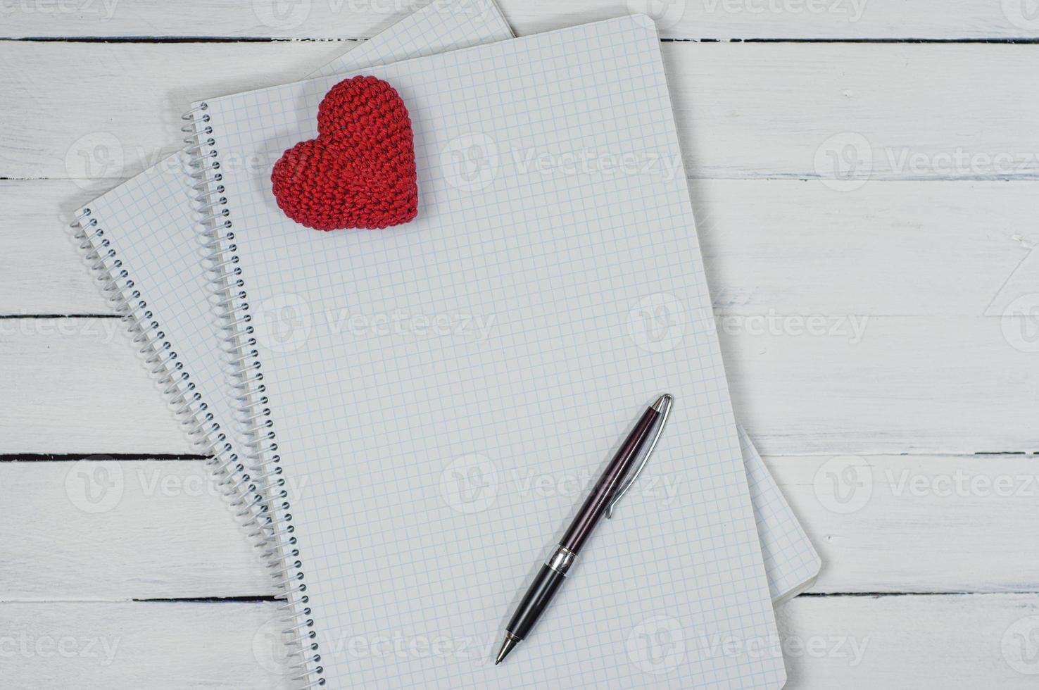 Open notebook with a pen on a white wooden surface photo