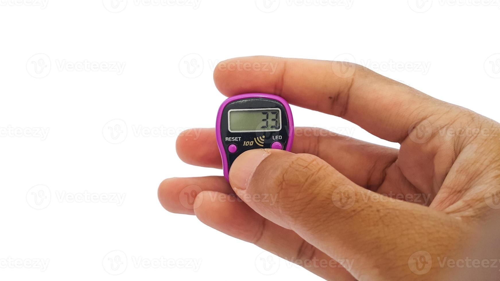 Hand holding digital counting counter or tasbih used by Muslims for dhikr photo