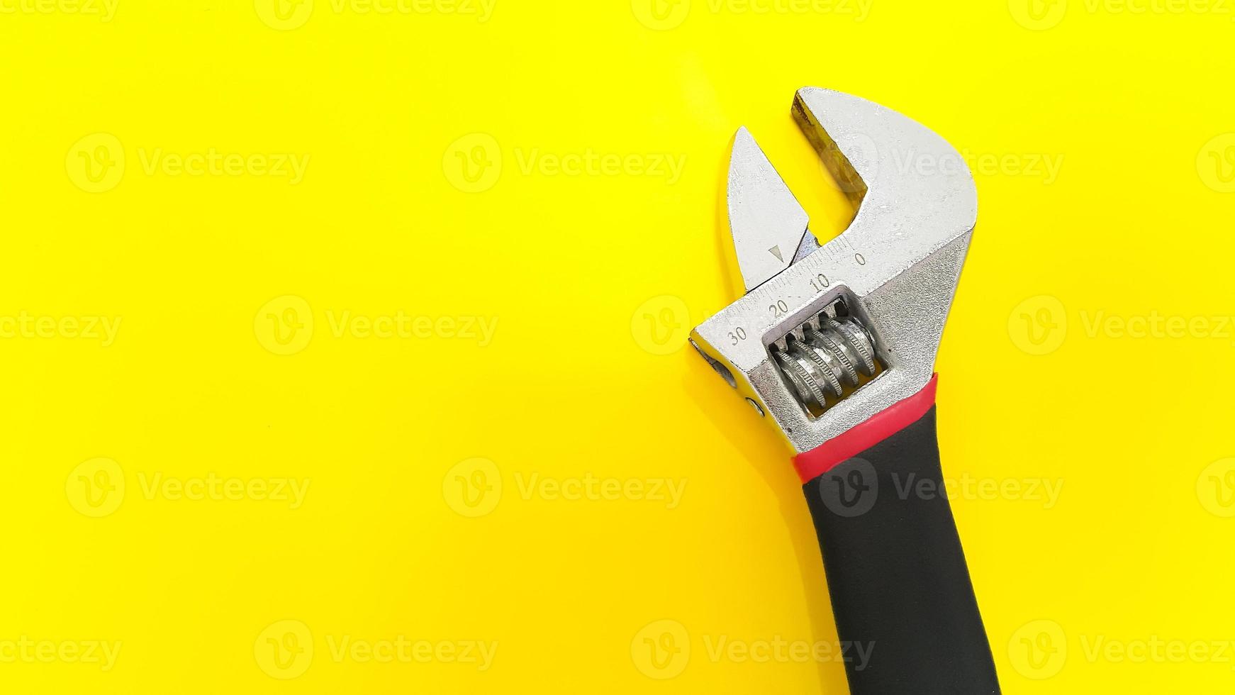 Adjustable spanner or adjustable wrench isolated on yellow background photo