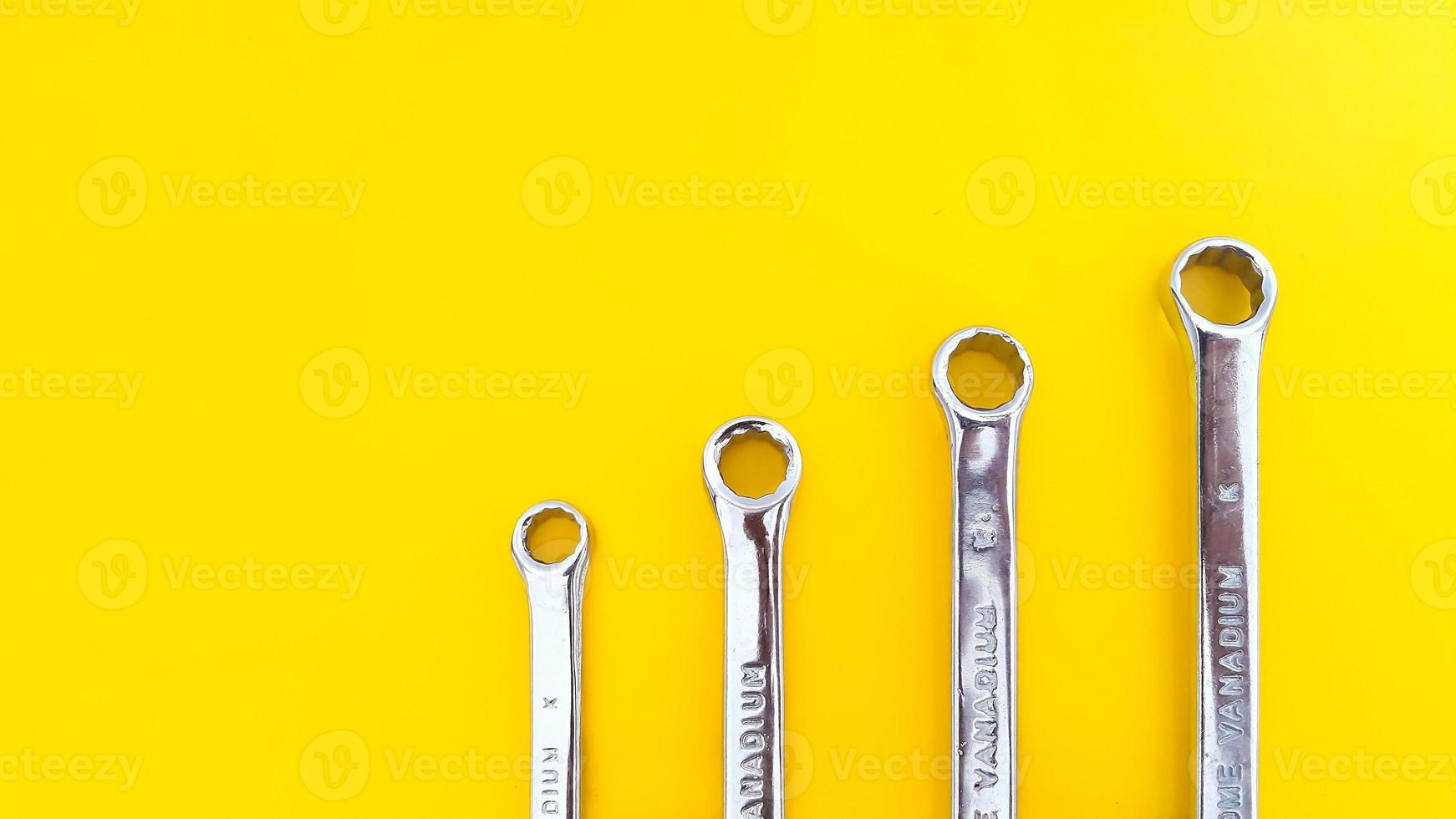 Various sizes of wrench or spanner isolated on yellow background. Mechanical Tool. photo