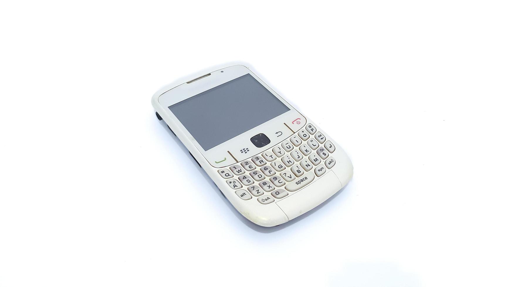 Jakarta, Indonesia, 2023 - Close up of obsolete white Blackberry mobile phone isolated on white background. Blackberry 8520 Gemini series. photo