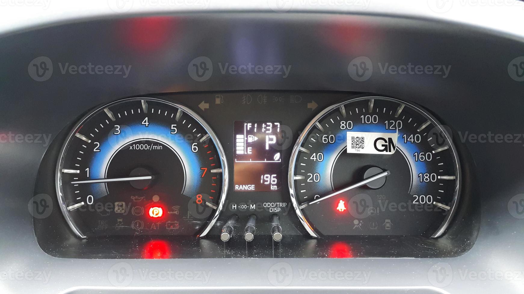 Close-up view of a car panel with a speedometer with brake and seat belt light indicators on photo