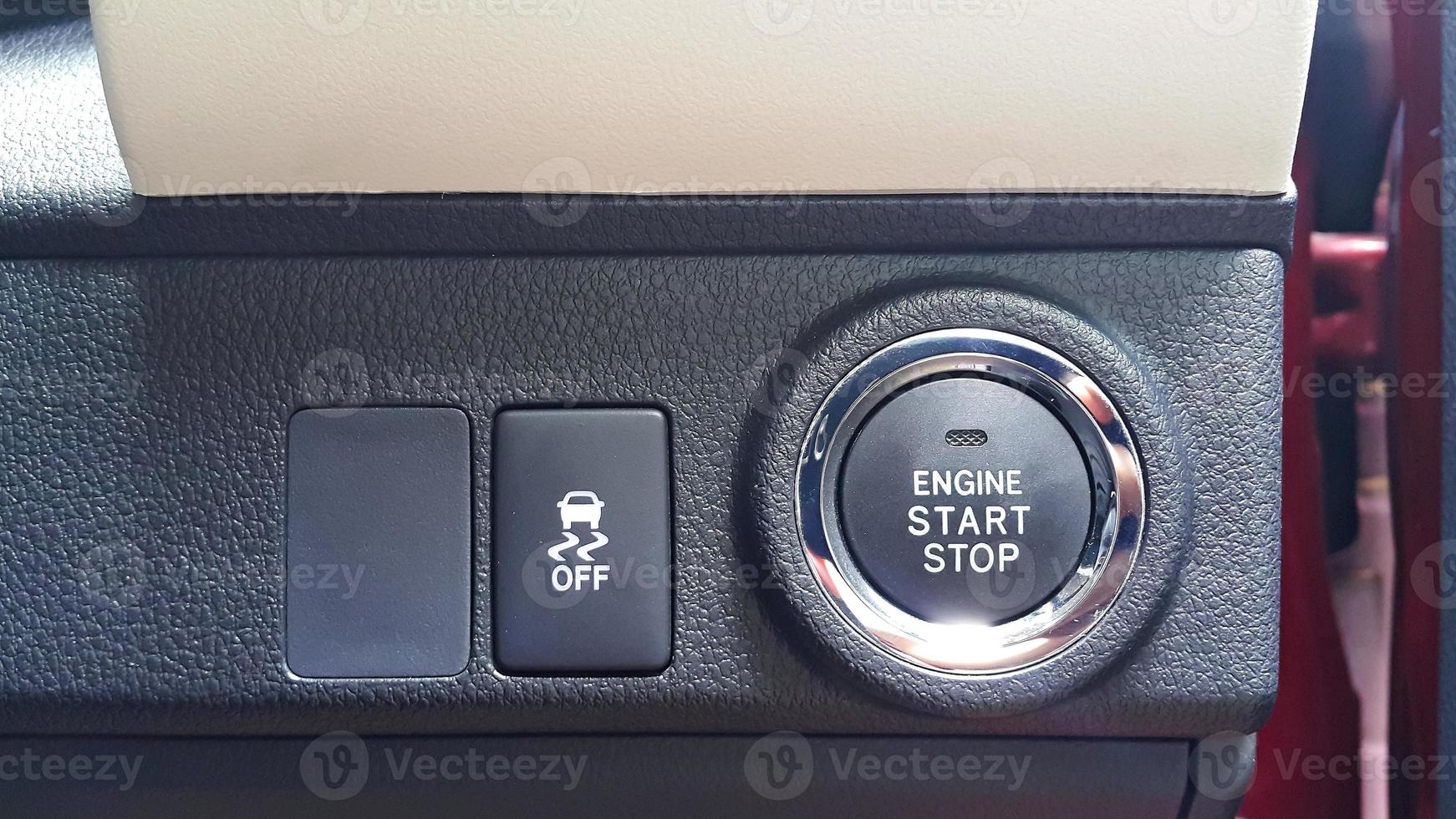vista de cerca del botón de parada de arranque del motor y el botón de control de tracción del coche foto