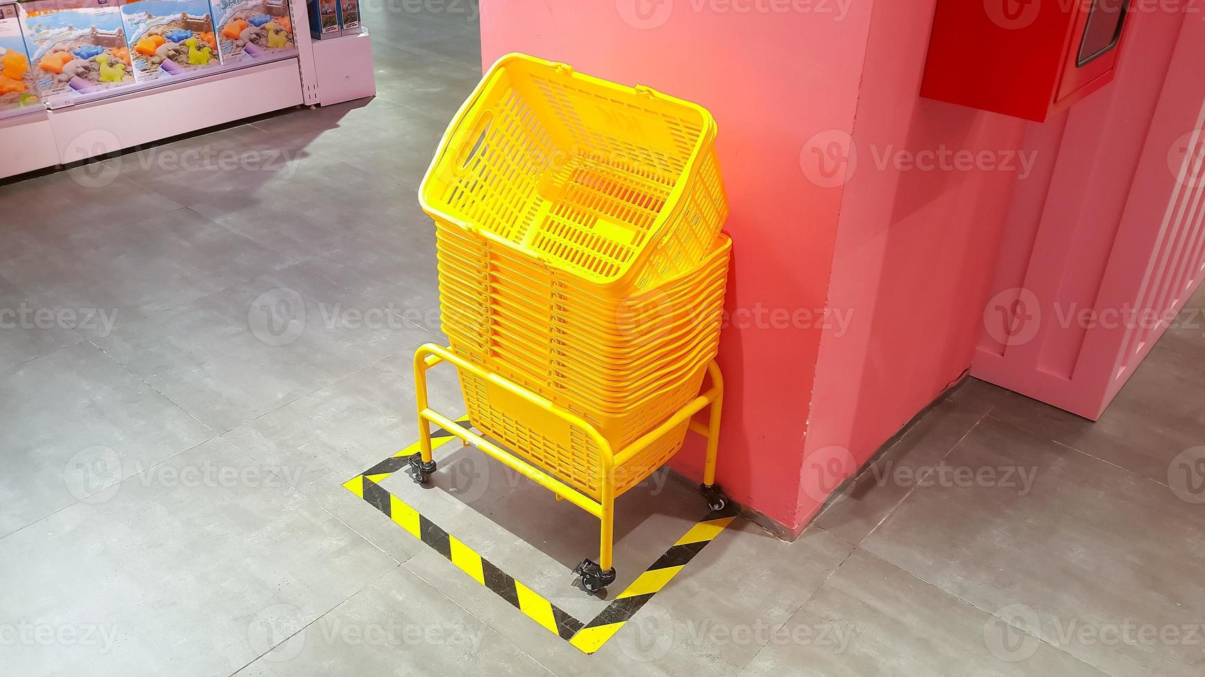 Pile of yellow plastic shopping baskets on the floor photo