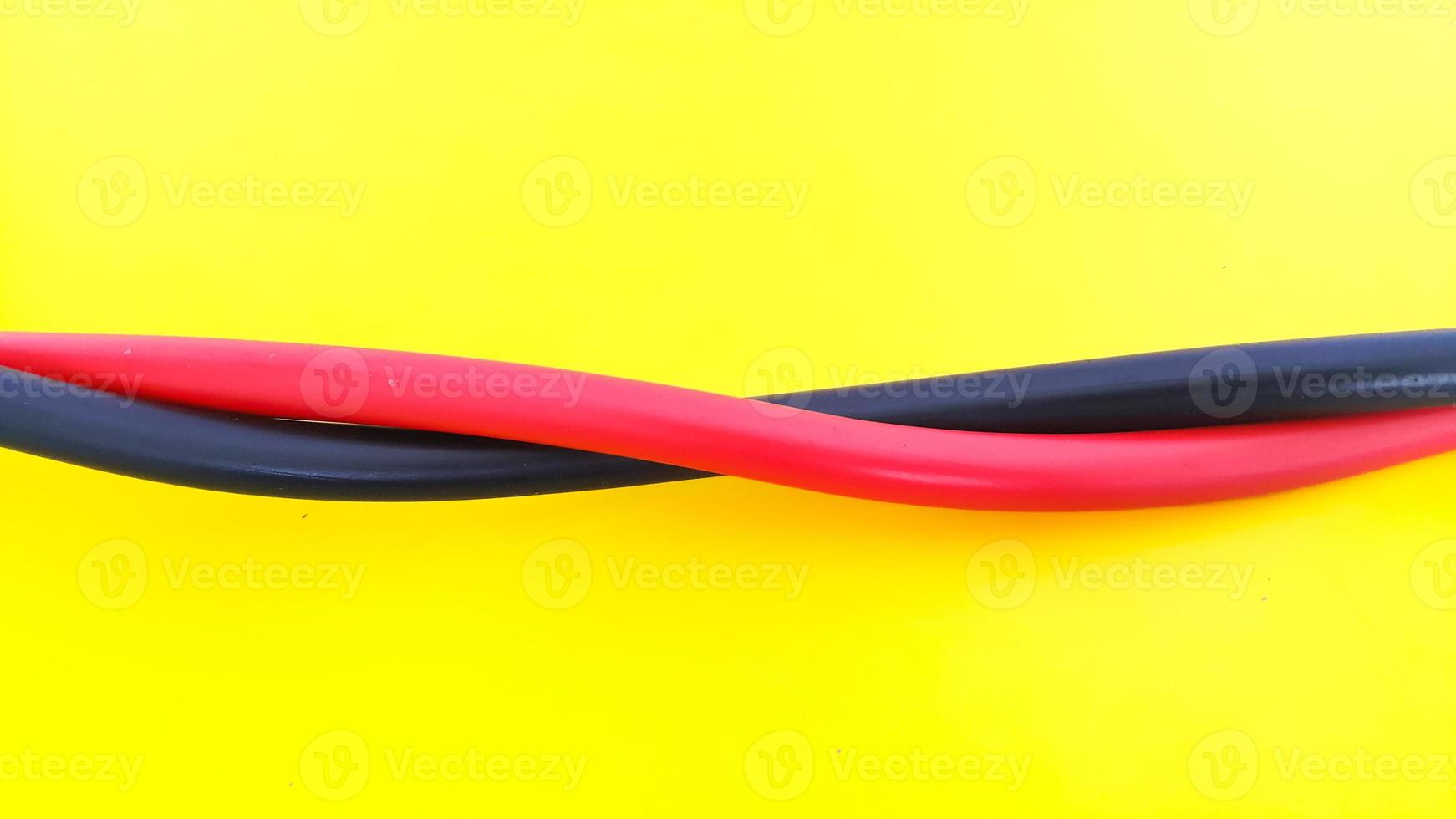 Close up view of red and black electric cables isolated on yellow background photo