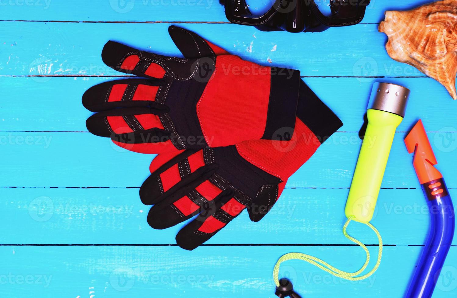 Red gloves for diving among other sports equipment photo