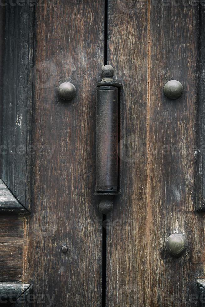 iron door hinge on old brown wooden doors photo