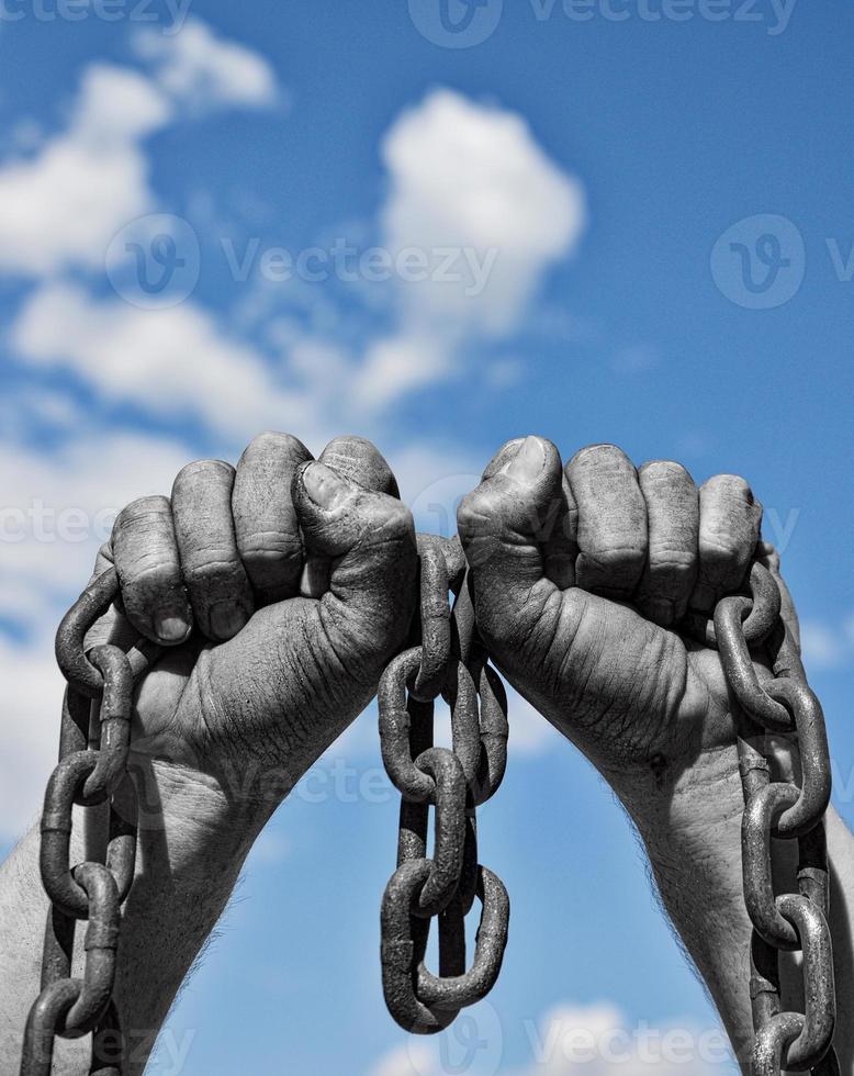 Two men's hands hold a rusty metal chain photo