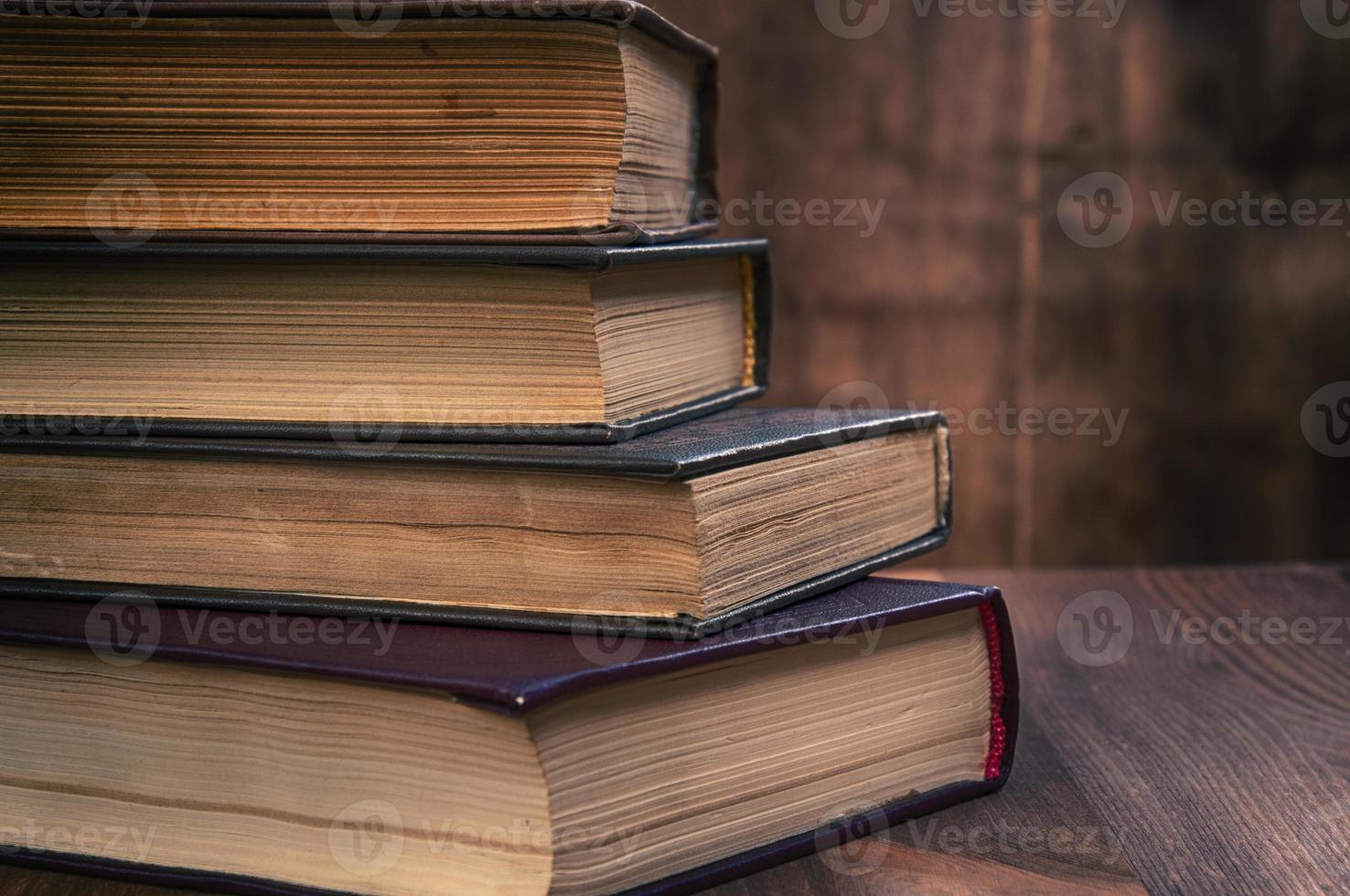 stack of old books on a brown wooden background photo