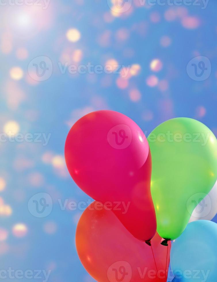 Multicolored balloons against the sky with bright sun photo