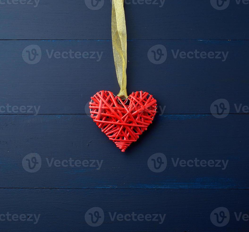 red wicker decorative heart hanging on golden silk ribbon photo