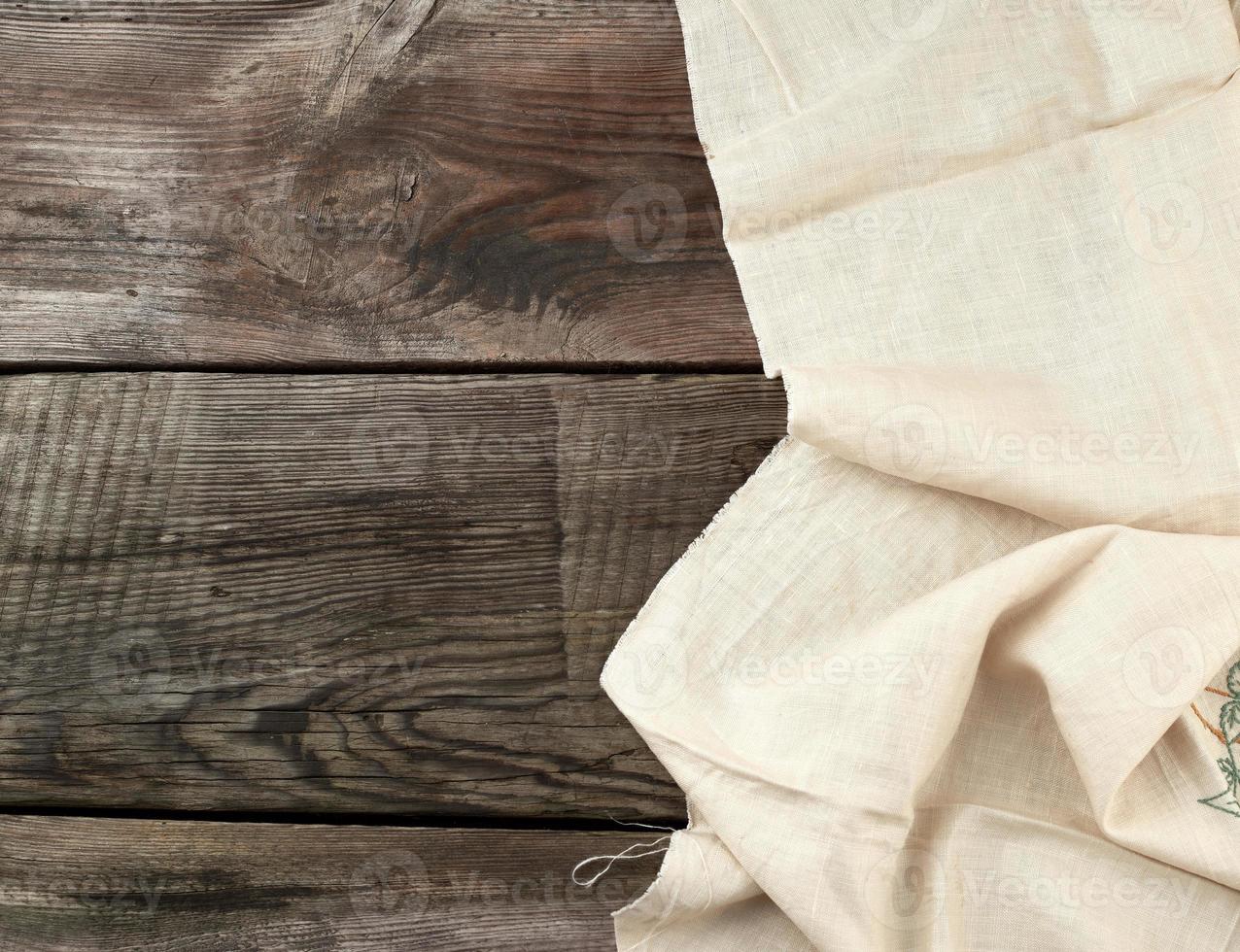 white kitchen textile towel folded on a gray wooden table from old boards, top view, empty space. Rustic texture. Retro background photo