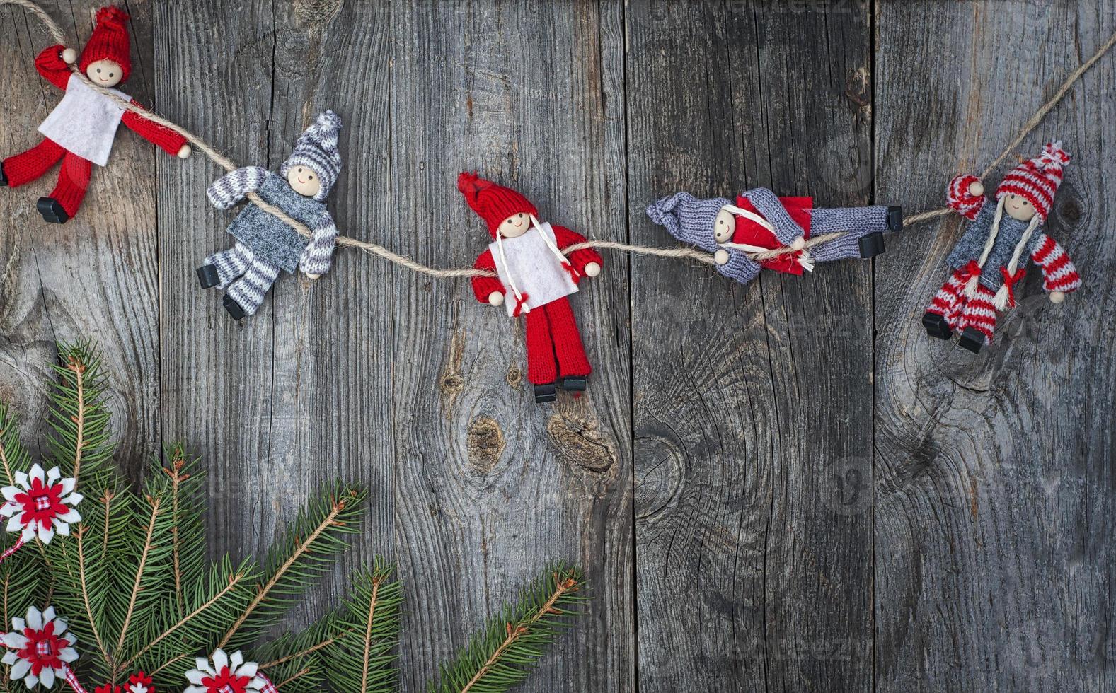 muñeca de trapo navidad colgando de la cuerda en la superficie de madera vieja gris foto