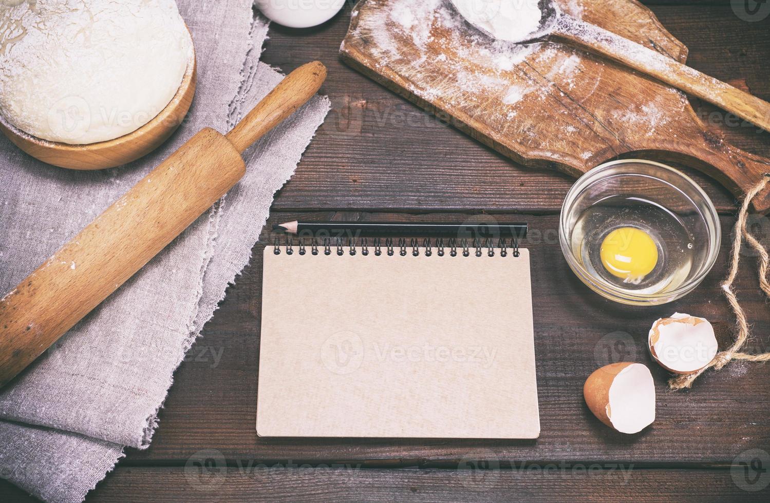 paper notepad with black pencil and dough with ingredients photo
