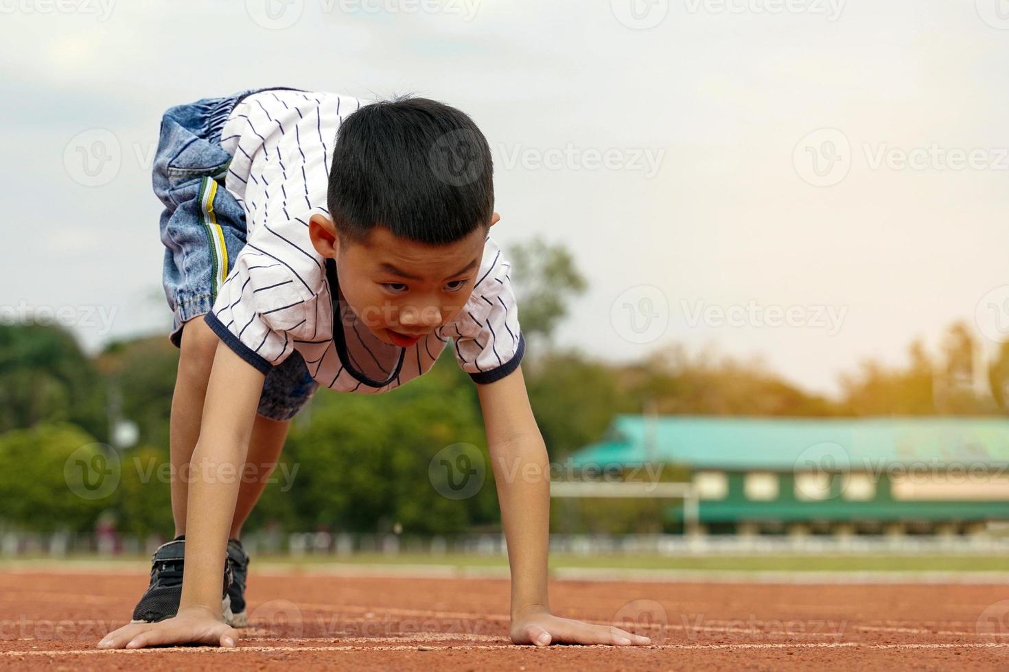 Asian boys started running on the track for the concept of outdoor play, outdoor activities, leisure activities, exercise. Soft and selective focus. photo