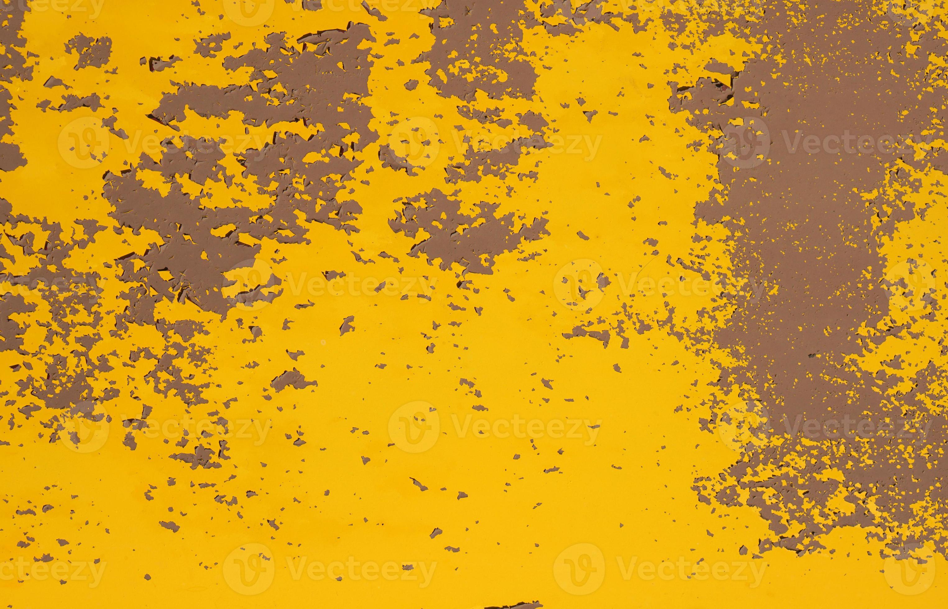 Old yellow grungy metal wall with peeling paint and rusty spots
