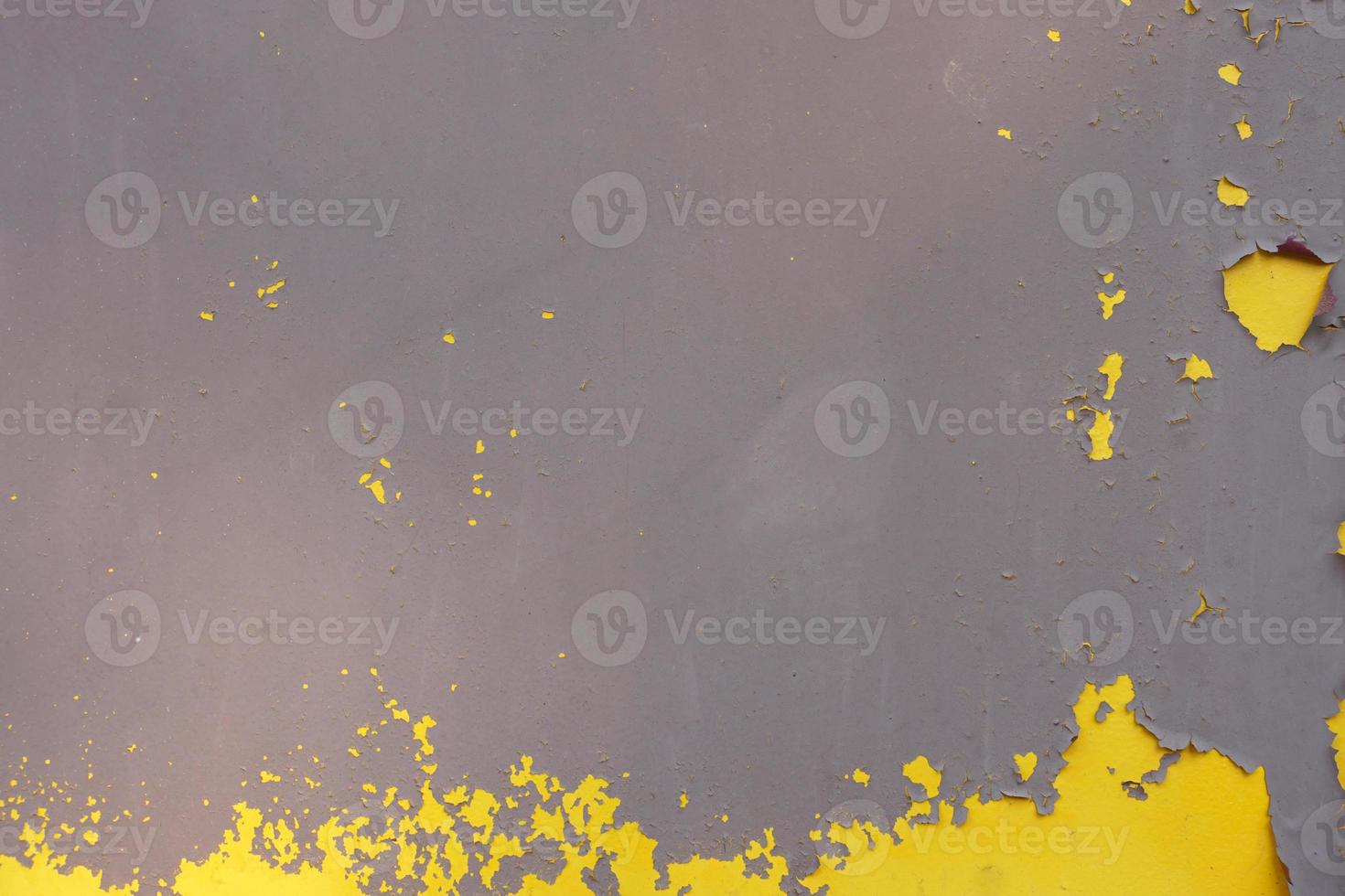 Old yellow grungy metal wall with peeling paint and rusty spots, industrial background photo texture