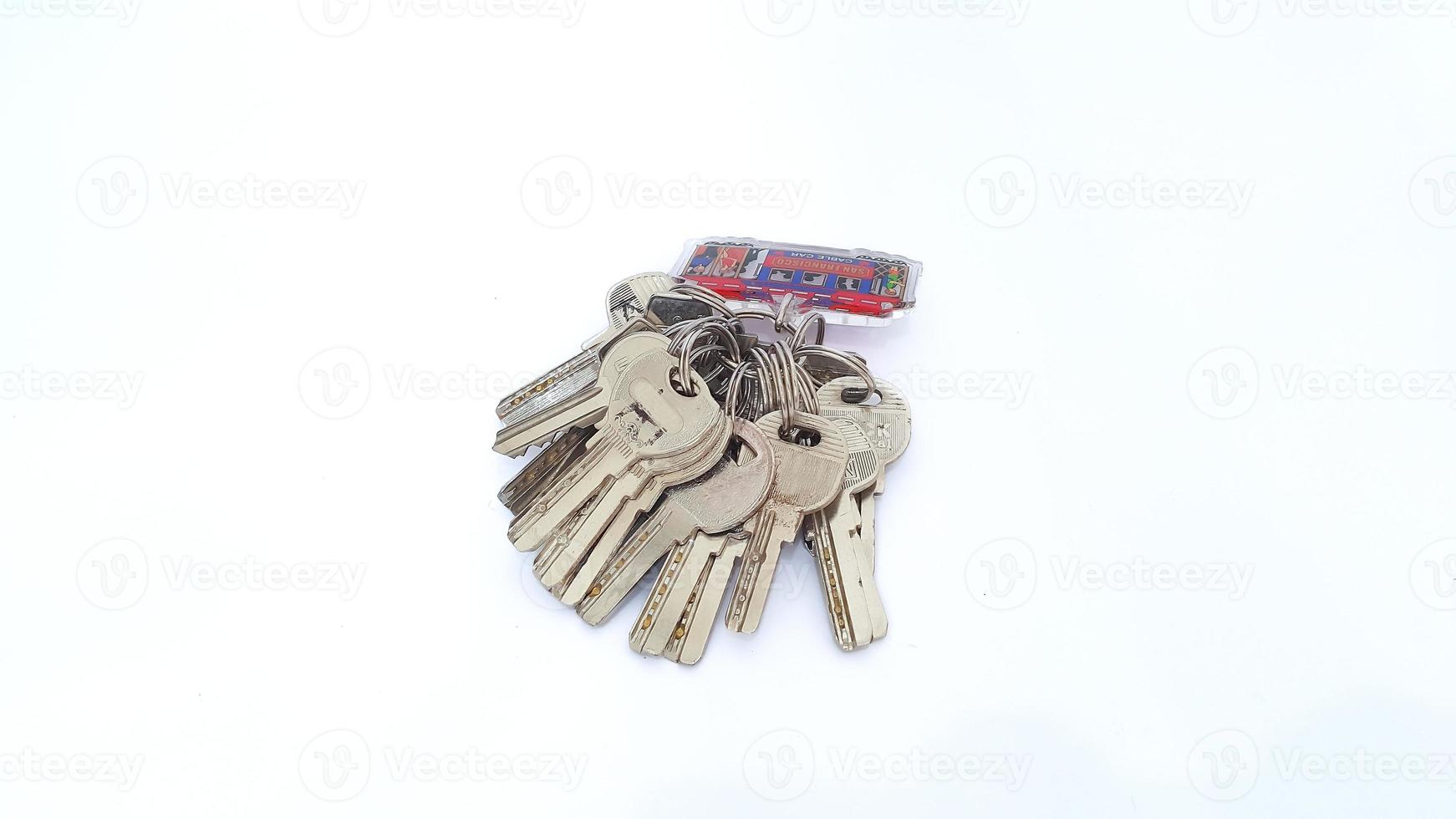 Close up of bunch of keys on key ring arrangement isolated on white background photo