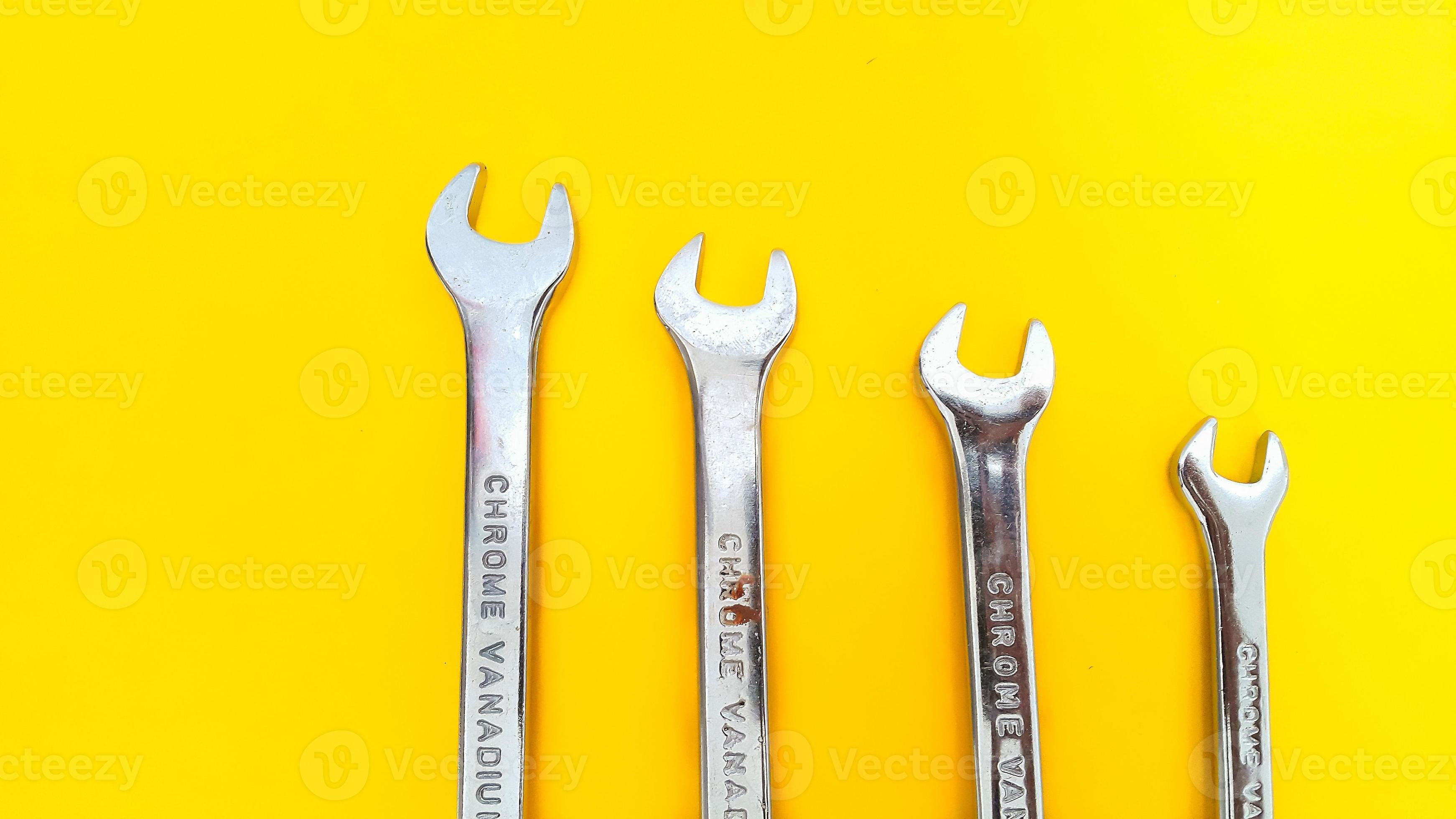 Various sizes of wrench or spanner isolated on yellow background