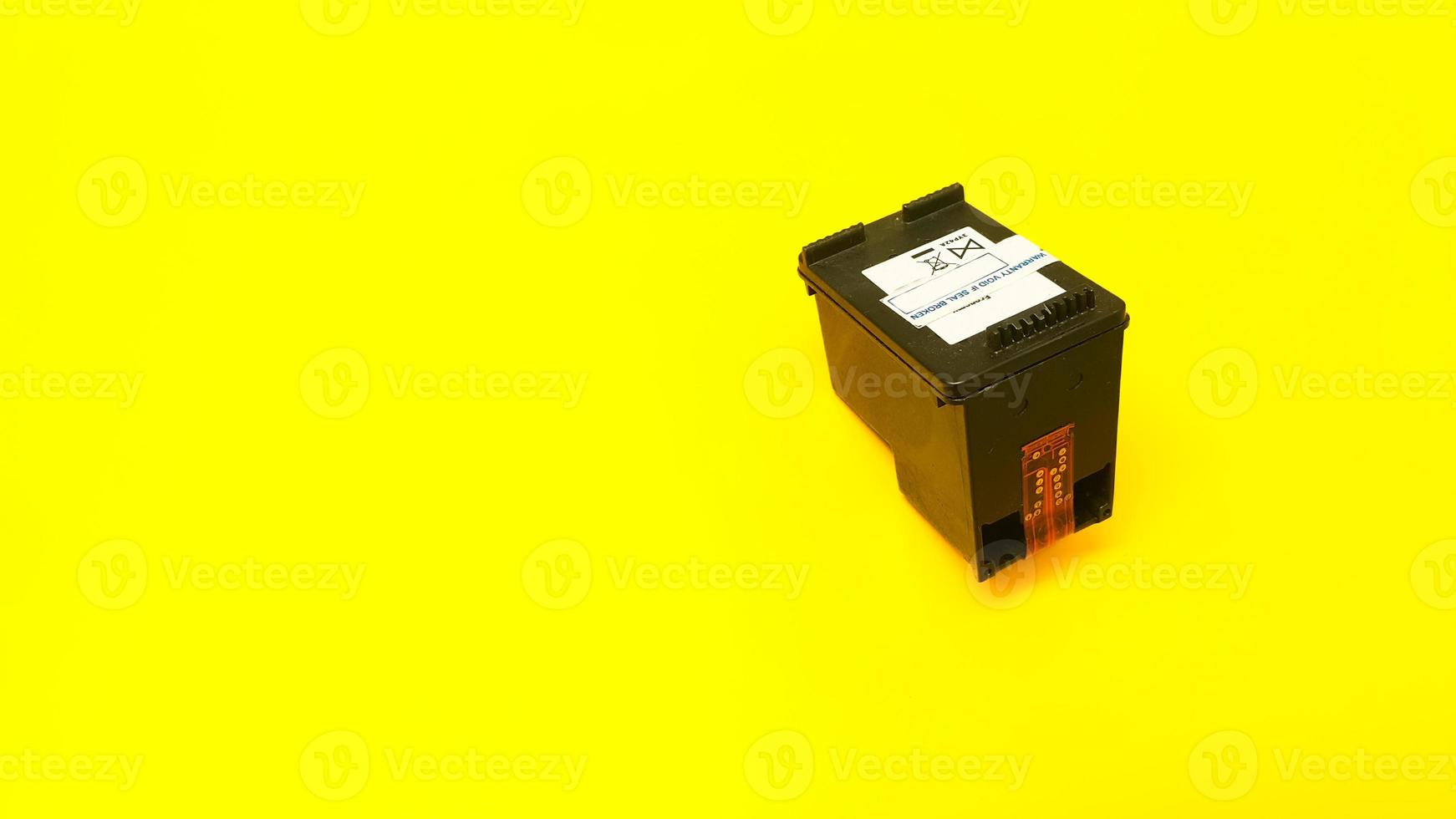 Printer black cartridge on yellow background photo