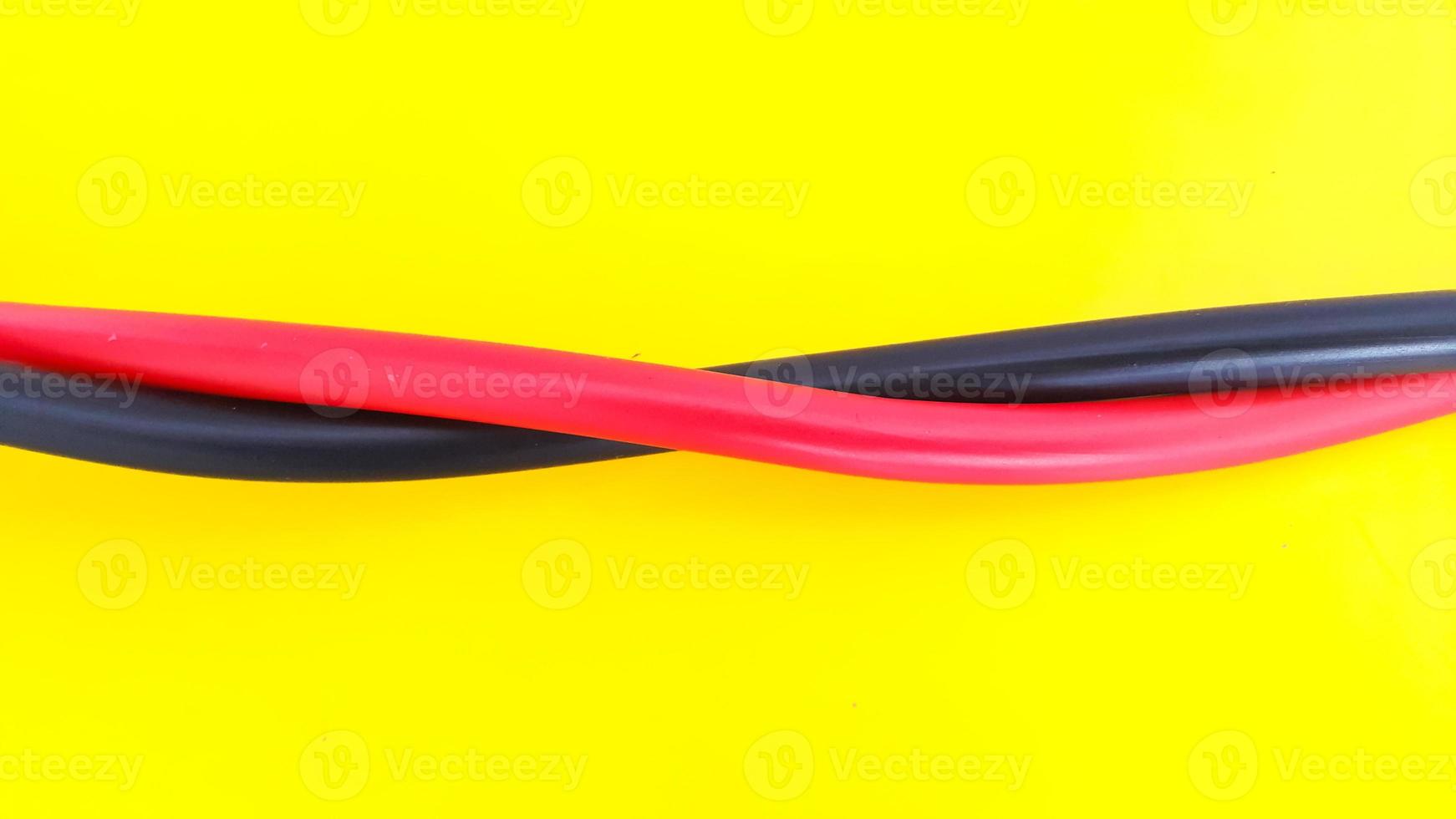 Close up view of red and black electric cables isolated on yellow background photo